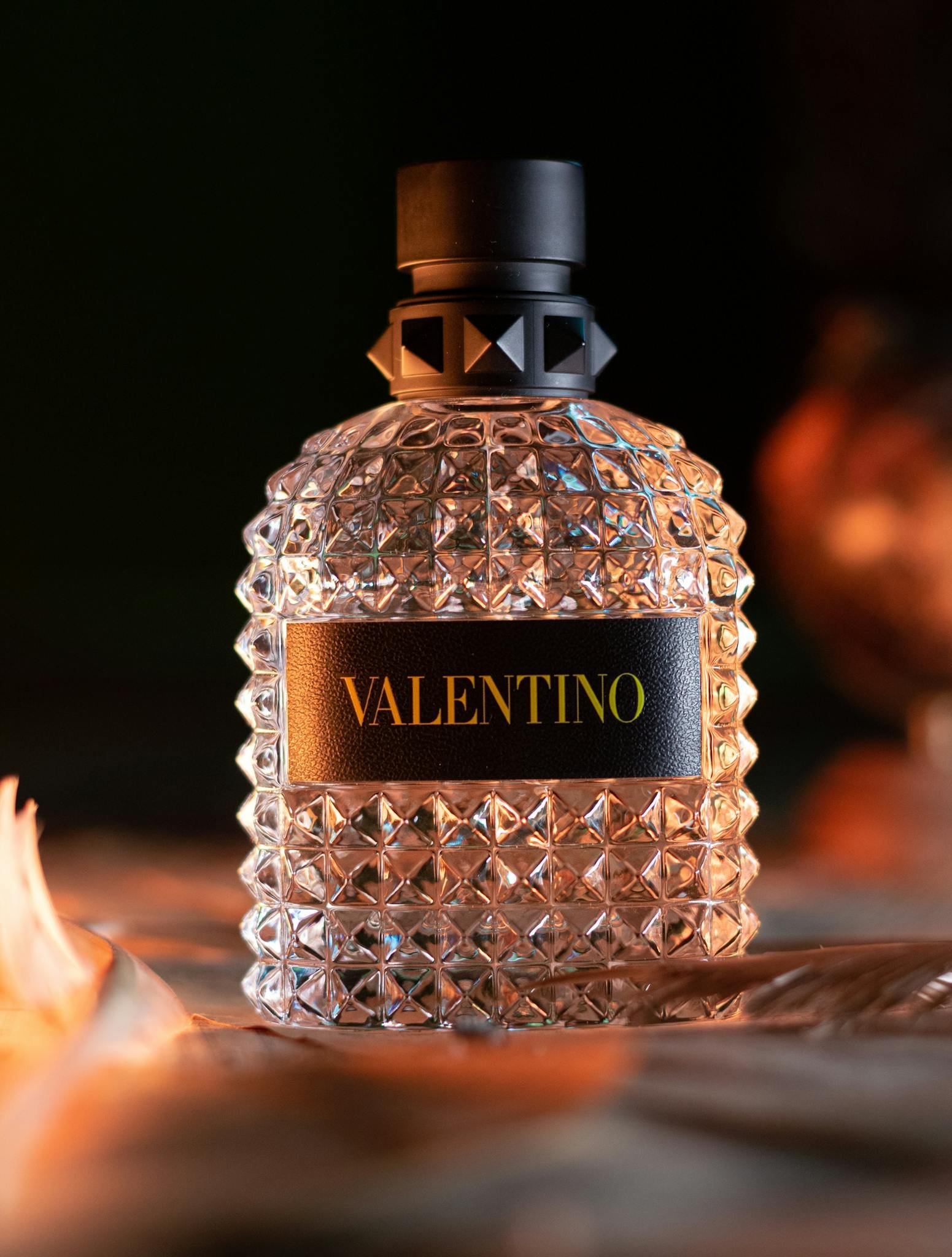 A luxury Valentino perfume bottle captured in warm lighting, exuding elegance.