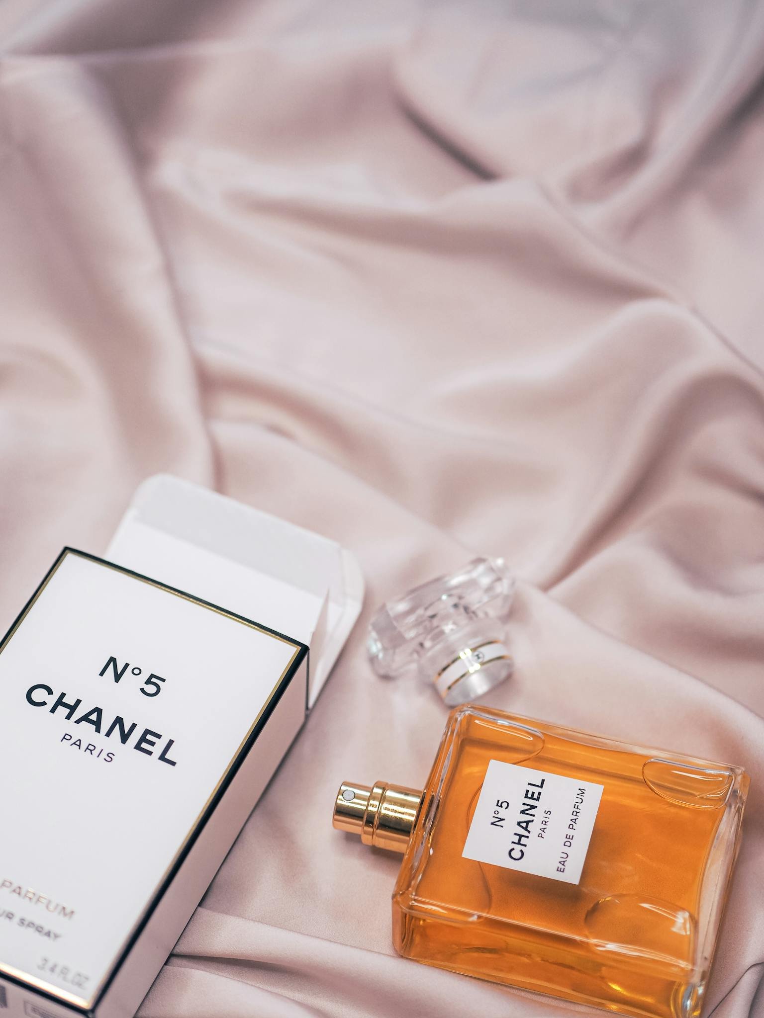 Chanel No. 5 perfume bottle elegantly displayed on soft fabric, exuding luxury and charm.